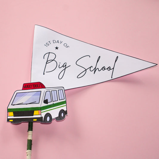 Pennant flag with '1st Day of Big School' text and a maxi taxi illustration on a pink background